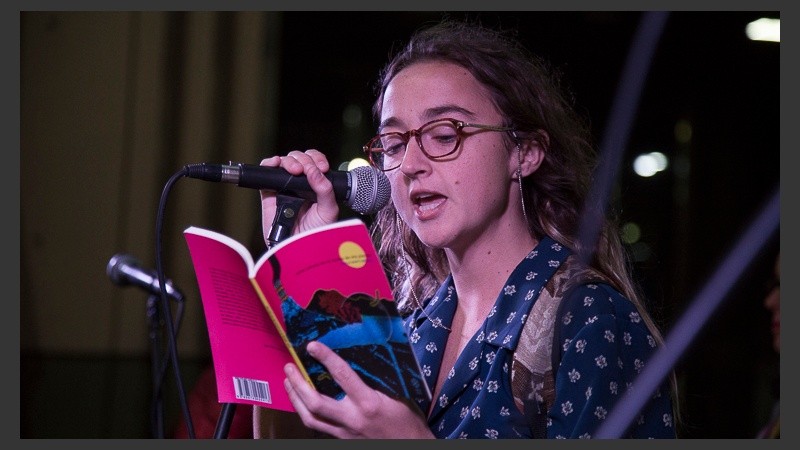 Una joven lee un libro en el escenario armado en San Martín y Córdoba.