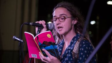 Una joven lee un libro en el escenario armado en San Martín y Córdoba.