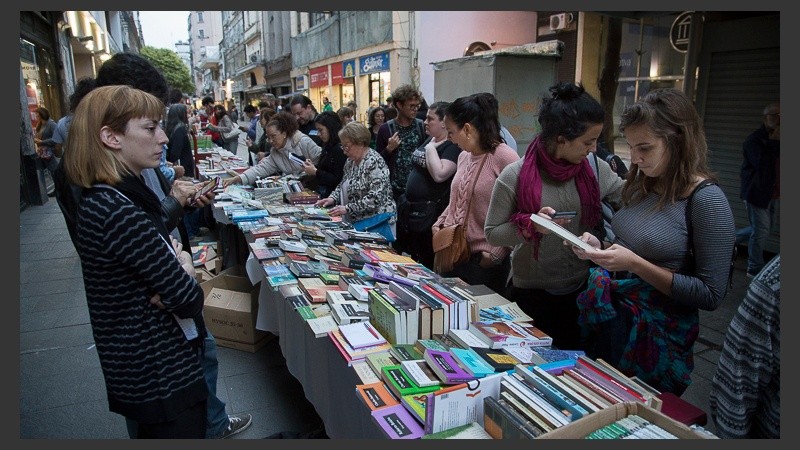Una mesa larga llena de libros para disfrutar.
