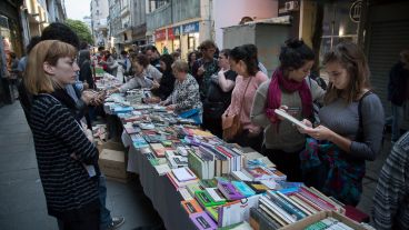 Una mesa larga llena de libros para disfrutar.