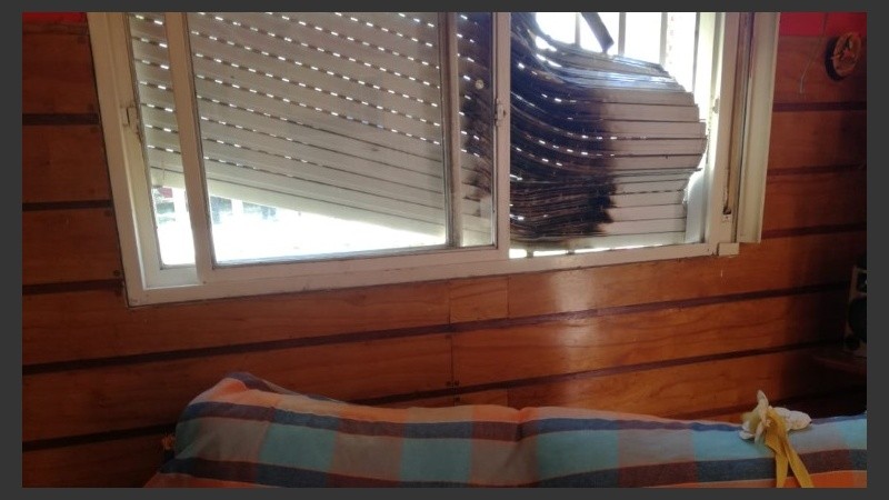 La persiana quemada vista desde adentro de la habitación.