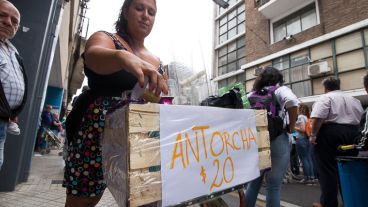 Una vendedora aprovecha para vender antorchas en la marcha en Rosario.