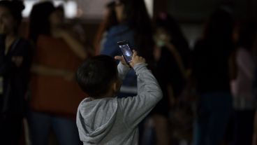 Un niño retratando la luna este lunes por la madrugada.