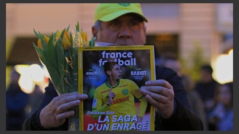  Un hombre muestra la portada de la revista France Football con la foto del futbolista argentino.