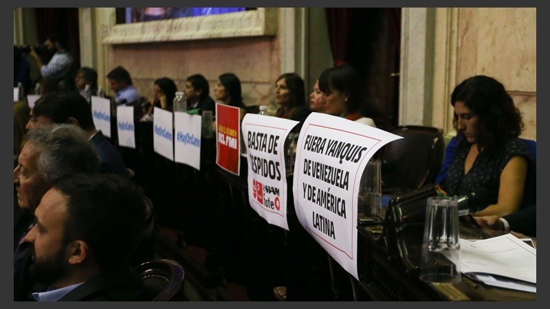 La oposición pegó carteles en sus bancas.