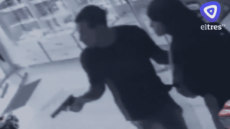 El ladrón, adentro de la farmacia, arma en mano.