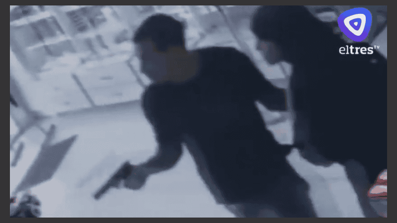 El ladrón, adentro de la farmacia, arma en mano.