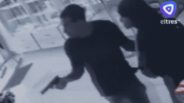 El ladrón, adentro de la farmacia, arma en mano.