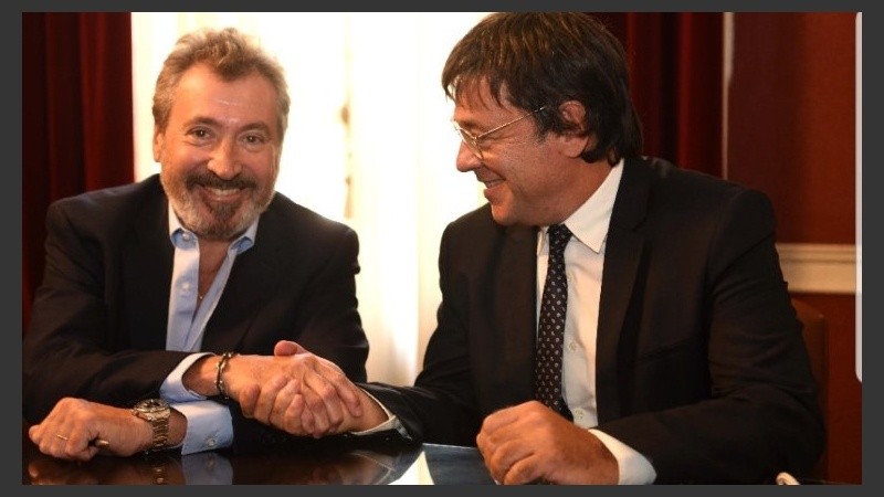 Daniel Vila y Gustavo Scaglione se saludan tras la firma de la compra.
