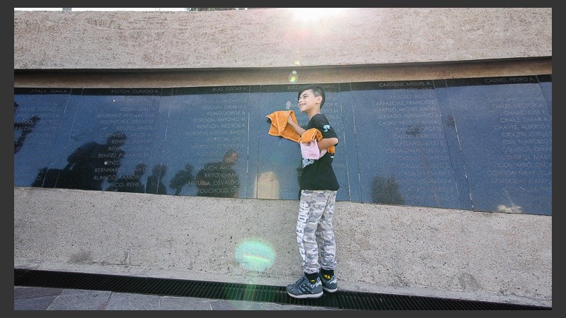 Nacho limpia las placas del Monumento a los Caídos en Malvinas.