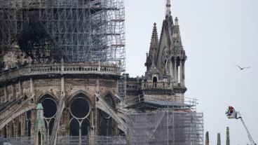 Varios bomberos trabajan en un elevador a la fachada de catedral de Notre Dame.
