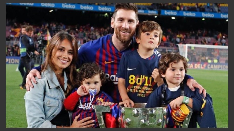 Messi festejando con su familia en el campo de juego y con la copa de la Liga. 