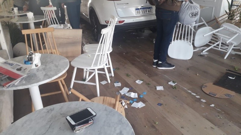 El Kia quedó entre mesas y sillas luego de atravesar los cristales.