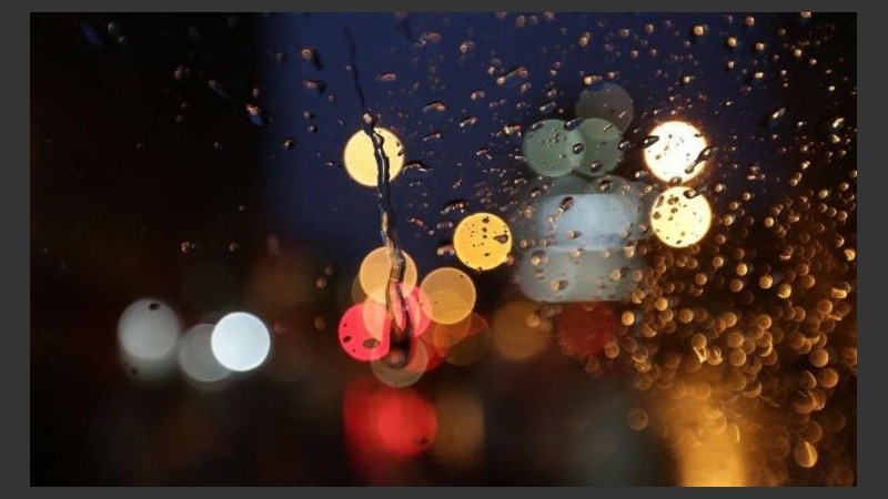 Las luces de la calle a través del agua de lluvia. 
