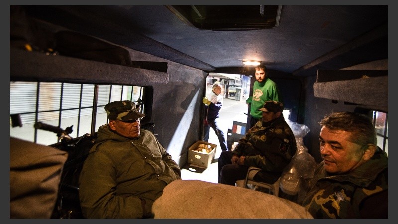 Alrededor de seis personas colaboran en el recorrido y en la entrega de una ración de alimento caliente.