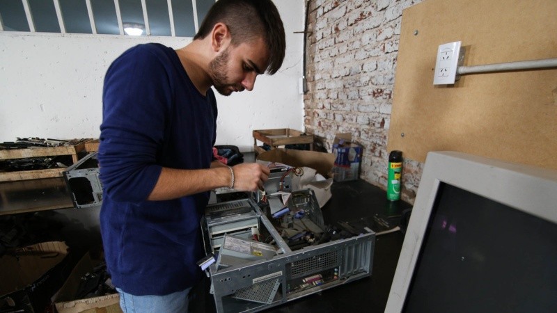 Uno de los jóvenes que trabaja en la inspección de los dispositivos electrónicos.