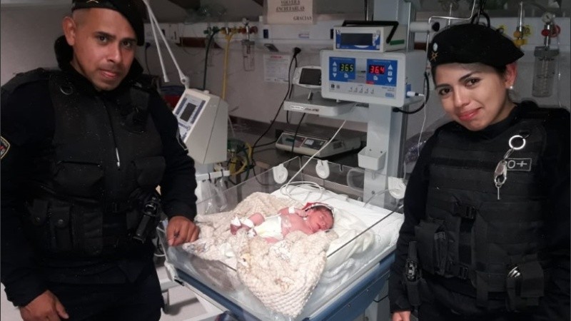 Los policías que asistieron el parto junto al bebé recién nacido.