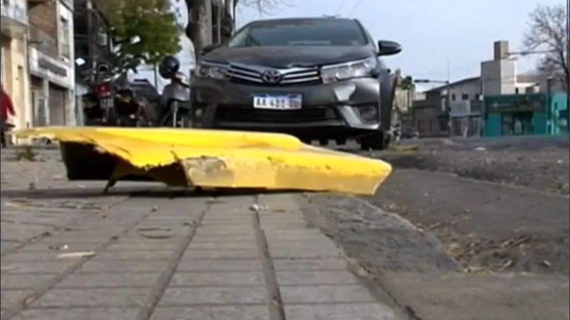 Uno de los autos chocados y restos del colectivo que quedaron en la vereda.