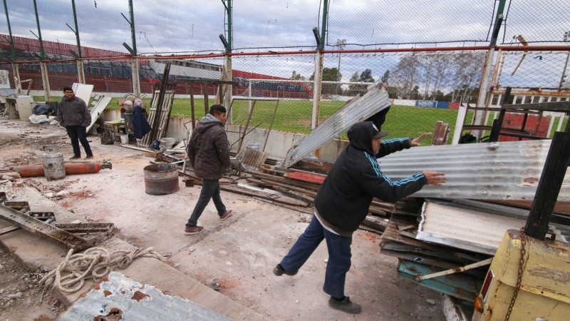Trabajadores limpiando el lugar donde se encontraba la vieja tribuna.