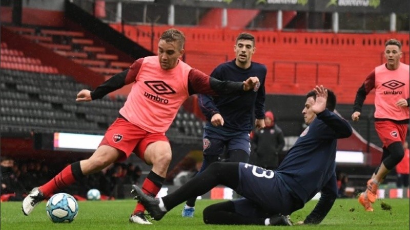 Cacciabue con la pelota y la marca. Detrás, Alexis Rodríguez.