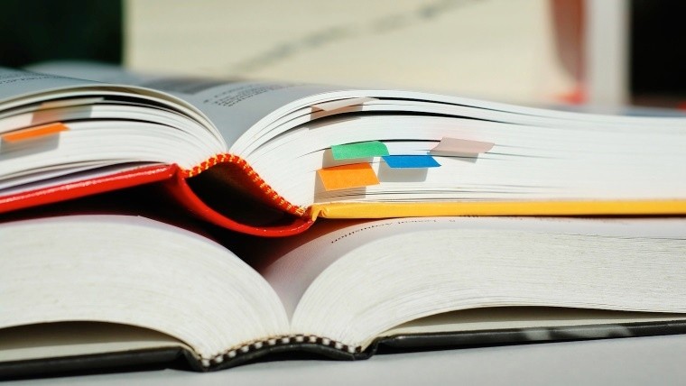 Two books are opened and piled together