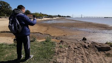 Un joven contempla la inmensa playa que quedó en el balneario de zona norte tras la retirada del agua.