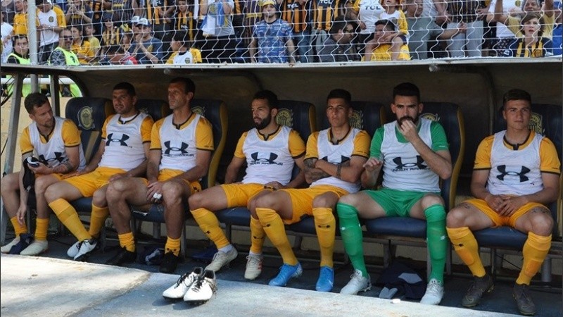 Marinelli, sentado a la derecha del banco de suplentes, al lado de Josué Ayala.