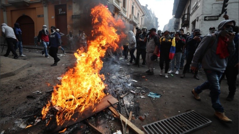 Manifestantes forman una barricada con fuego durante enfrentamientos con la policía, en el centro de Quito.