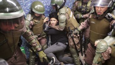 Un joven manifestante atrapado por carabineros en el metro de Santiago.