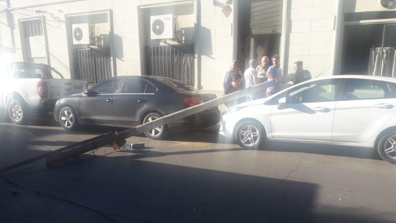 El poste caído sobre la vereda en la cortada. 