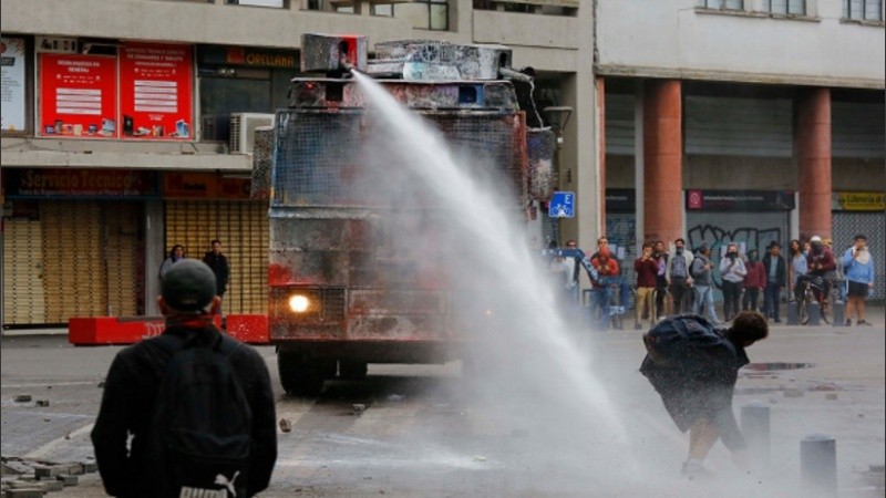 Carro lanza agua en la Plaza de la Independencia, en el centro de Concepción, Chile. 