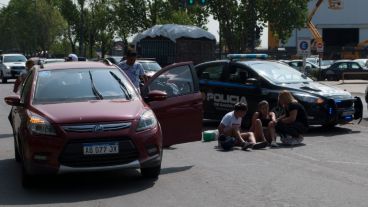 El auto chocado por el camión y la joven herida en el piso.