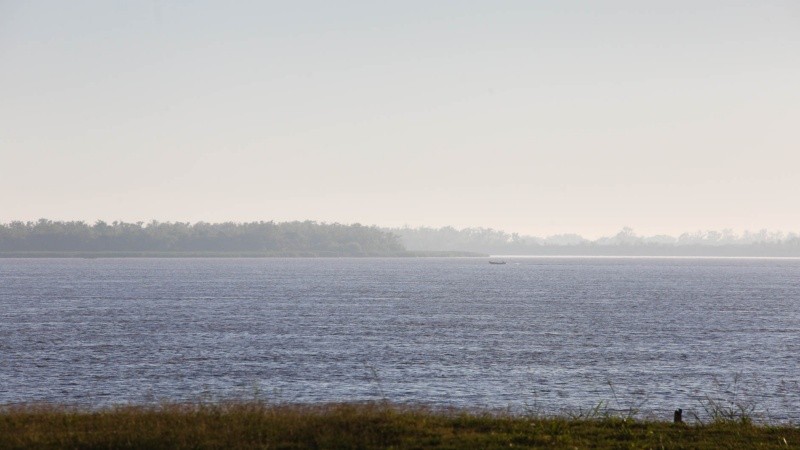 A lo lejos. Una pequeña embarcación navega entre el humo isleño. 