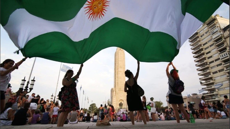 Mujeres con una bandera argentina de color verde, en favor del aborto legal, en el Monumento. 