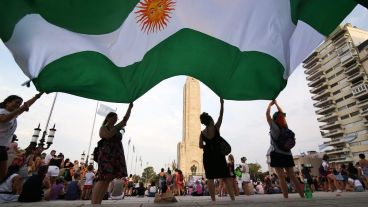 Mujeres con una bandera argentina de color verde, en favor del aborto legal, en el Monumento.