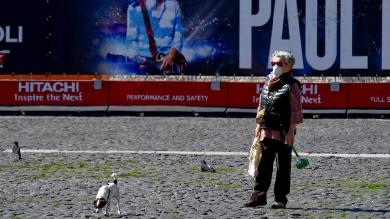 Una mujer con barbijo en calles italianas.