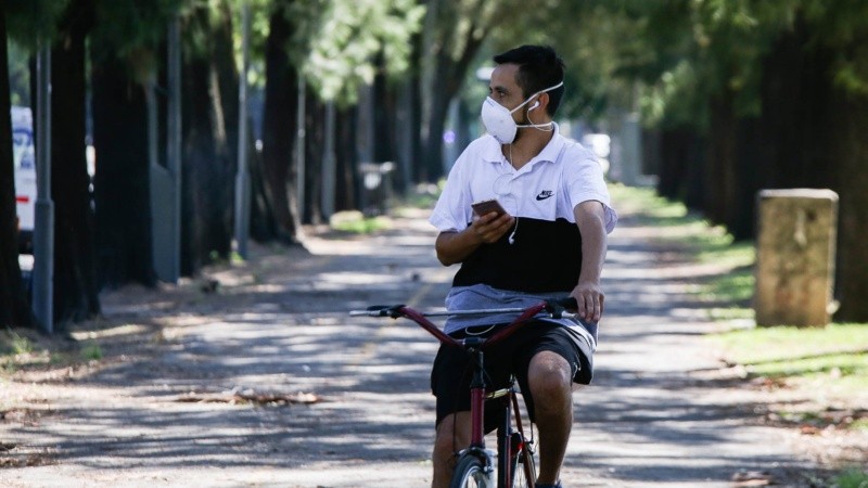 Un joven circula en su bicicleta con barbijo en el Parque Independencia.