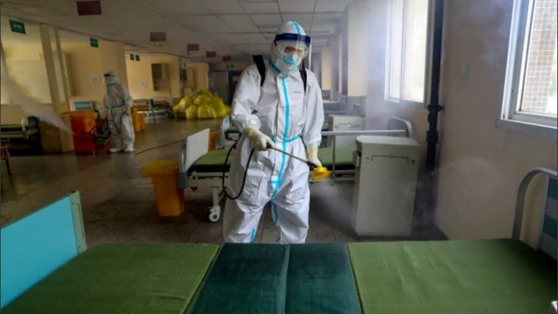 Un trabajador con traje de protección desinfecta el Hospital N° 7 de Wuhan.