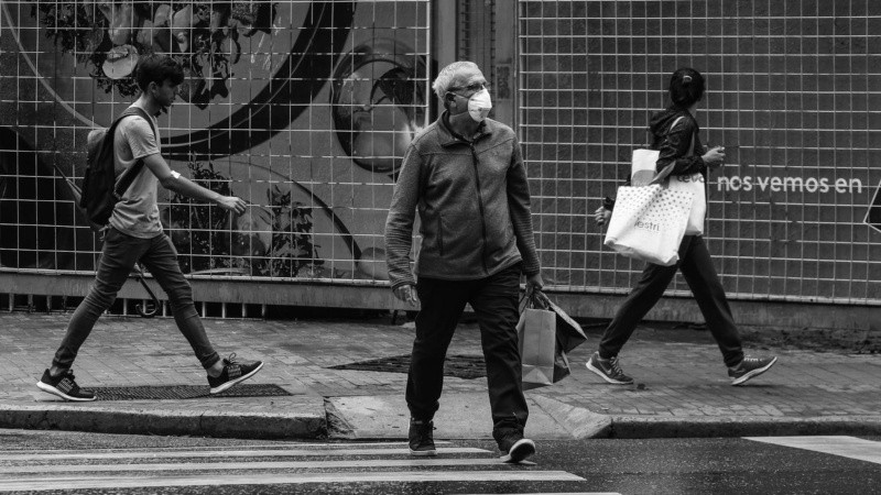 En una esquina céntrica un hombre intenta cruzar la calle.