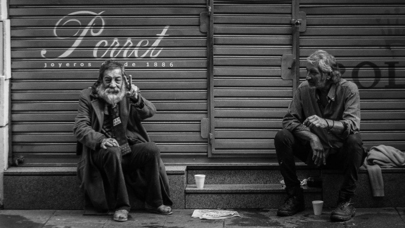 Dos hombres en peatonal Córdoba. Uno de ellos saluda a cámara. 