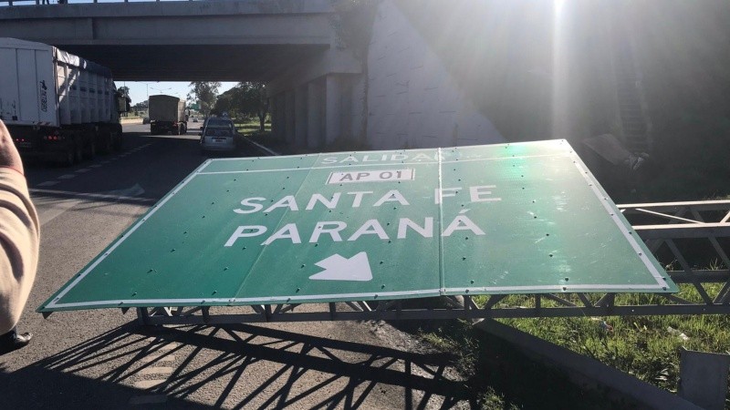 El enorme cartel derribado con la indicación de la salida hacia Santa Fe y Paraná. 