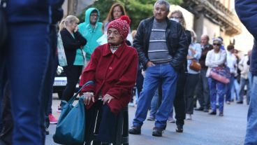 Expuestos al virus: multitud de gente espera cobrar en los bancos.