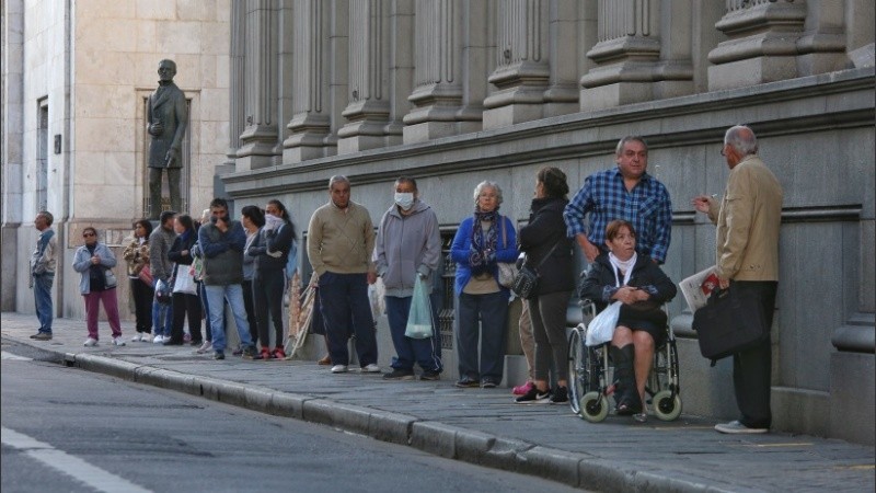 Expuestos al virus: multitud de gente espera cobrar en los bancos. 
