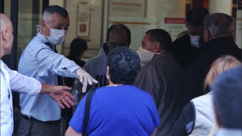 Expuestos al virus: multitud de gente espera cobrar en los bancos. 
