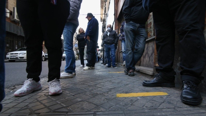 Expuestos al virus: multitud de gente espera cobrar en los bancos. 