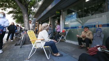 Expuestos al virus: multitud de gente espera cobrar en los bancos.