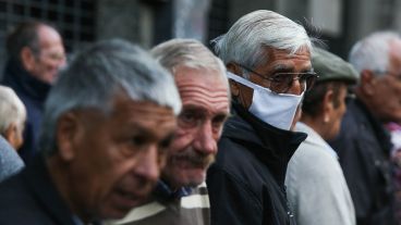 Expuestos al virus: multitud de gente espera cobrar en los bancos.