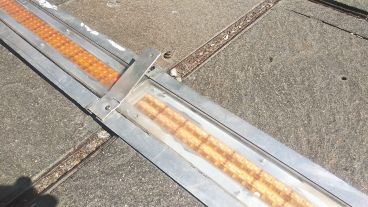 El soporte de metal levantado que ocasionó el tropiezo del hombre.