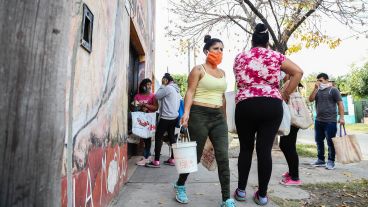 Personas de todas las edades van en busca de una ración. Puede ir una persona en representación familiar. Es obligatorio el uso de barbijo para retirar comida.