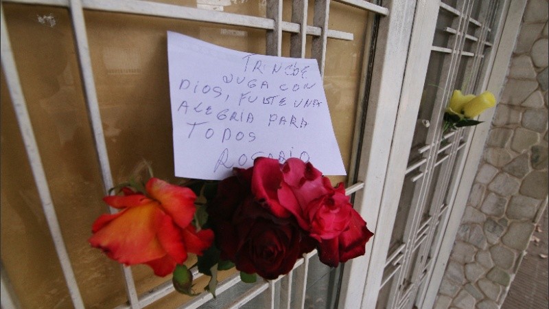 Flores y papeles escritos en la puerta de la casa del Trinche Carlovich.